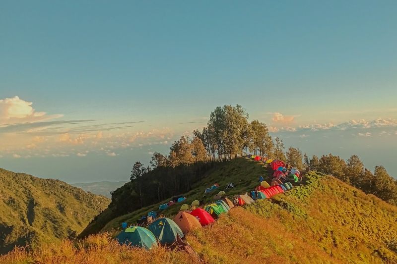 Mount Rinjani campsite on crater ridge with colorful tents during 3D2N non-summit trekking Senaru Torean